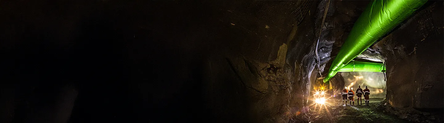 Miners inspecting an underground ventilation system in a mine.