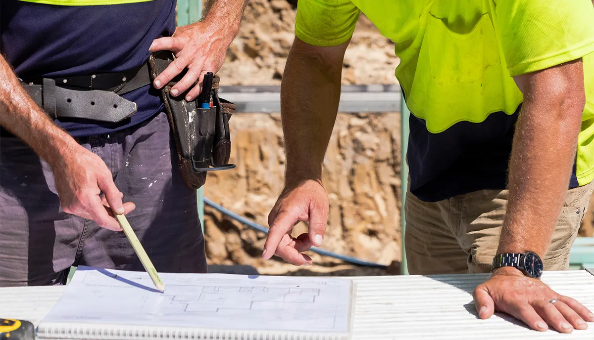 Two tradesmen review construction plans
