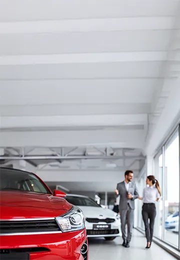 Two colleagues inside their car dealership workplace.