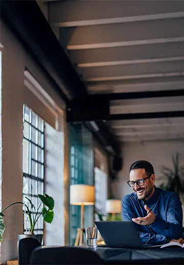 Employee having an online meeting with his colleagues, talking about a project.
