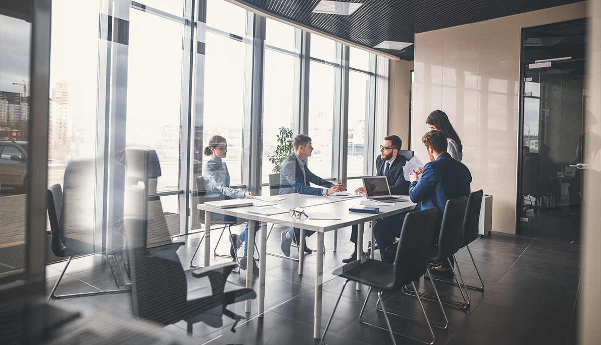 A group of business partners sit around a table and consider subcontractors