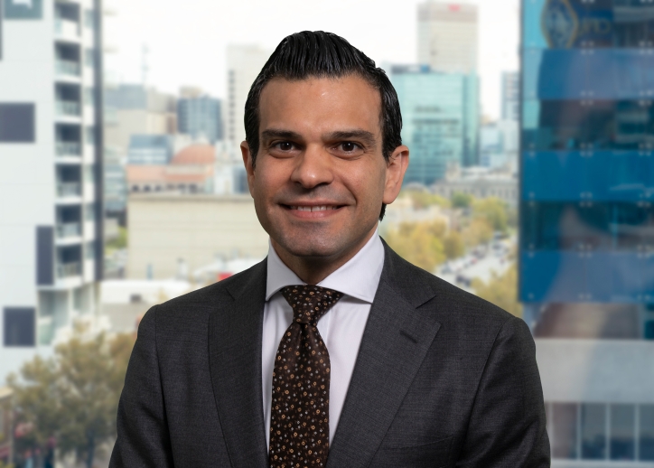 A photo of George Yatzis looking straight ahead with a view of Adelaide in the background