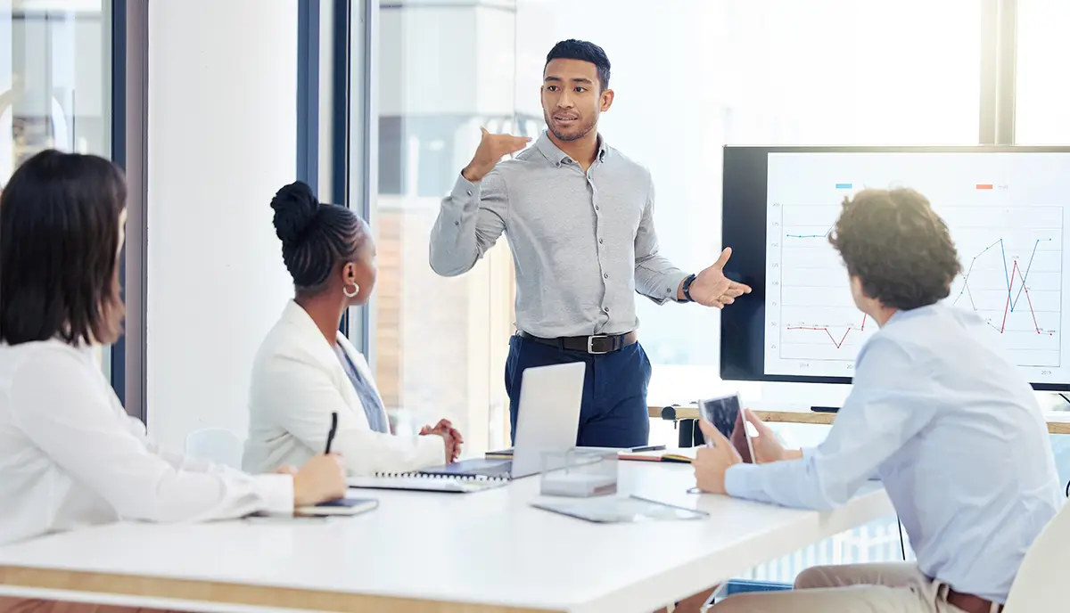 Businessman, meeting and coaching in presentation for data, graph or chart on team project at office. Man, coach or mentor training staff on corporate statistics, analytics or marketing at workplace