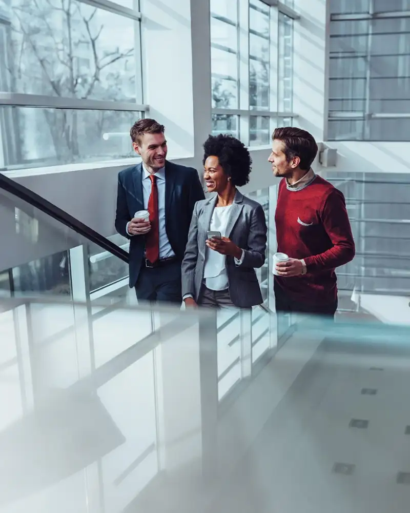 A group of coworkers climb a staircase while chatting to each other