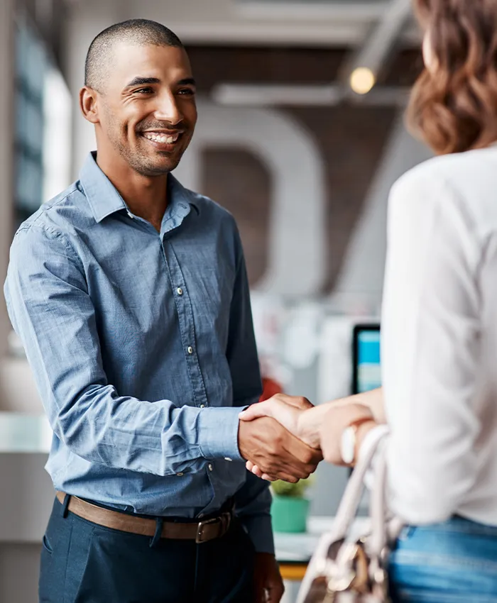 A young man shakes hands with a happy client