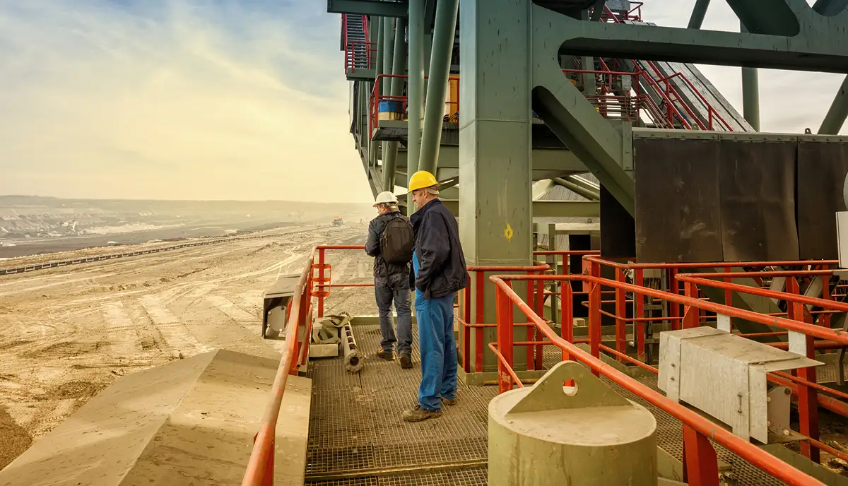 Two men wearing hard hats on a construction site. 