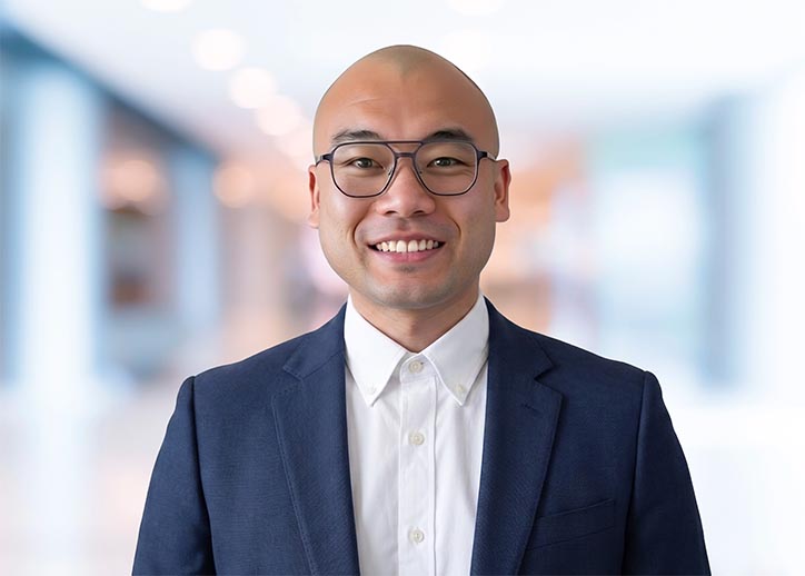 Dominic She, Business Services, smiling at the camera.